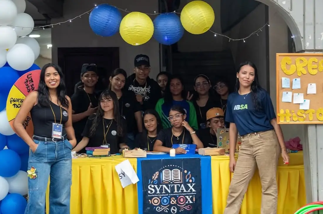 Integrantes de Syntax en su stand, bajo faroles azules y amarillos.